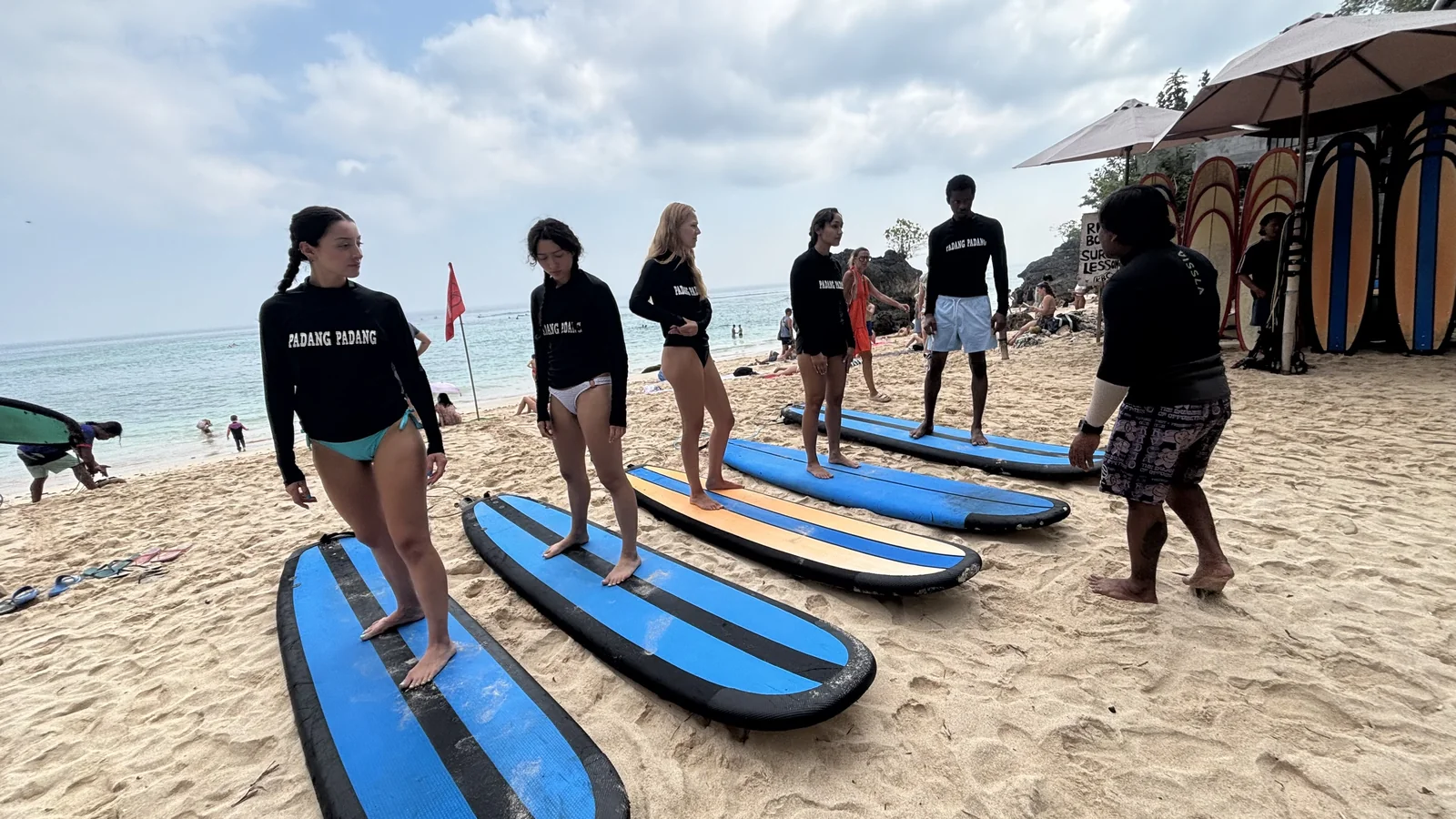 Latihan posisi berdiri bersama instruktur di atas pasir pantai